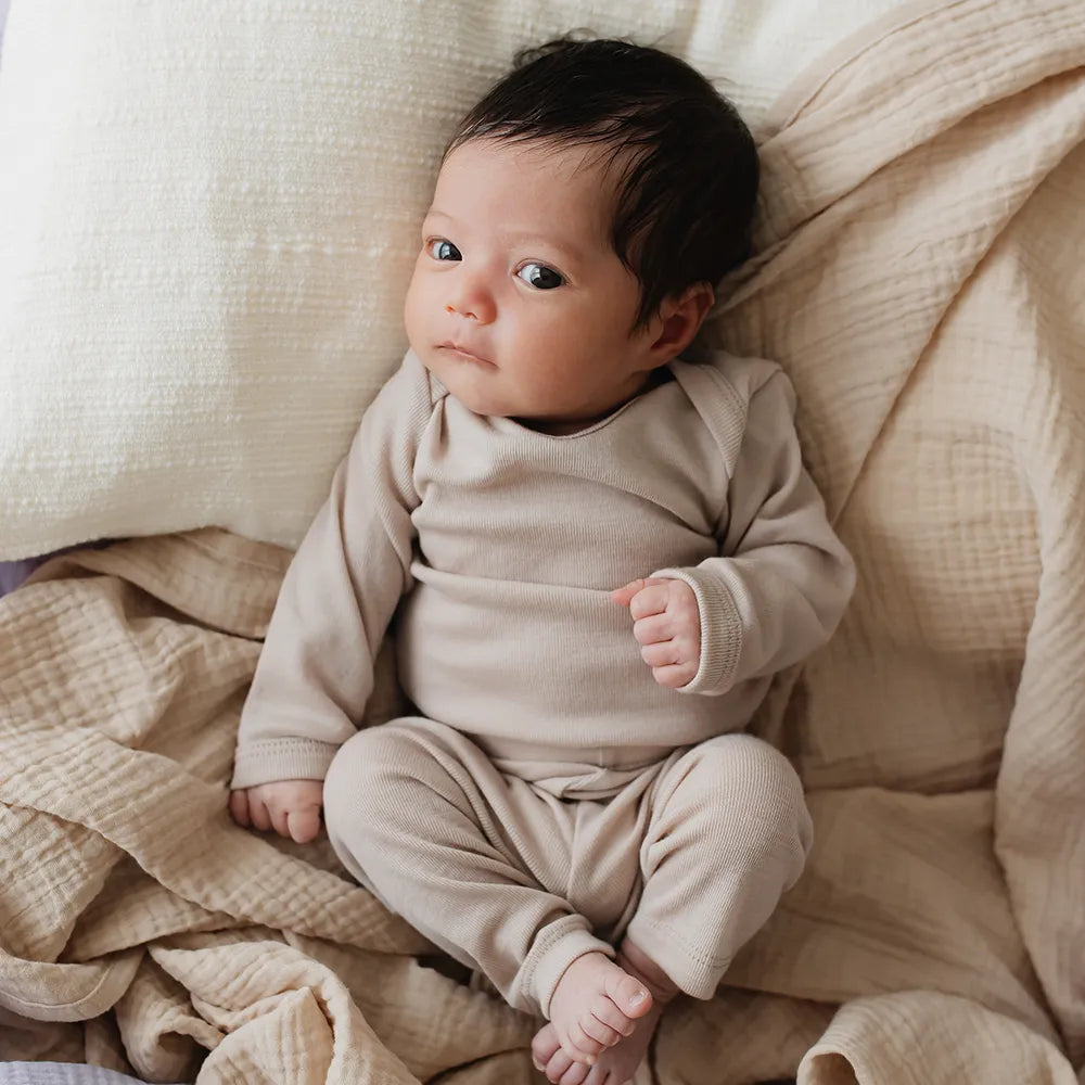 Body aus Bio-Merino-Schurwolle in Nude, Tragebild mit Baby
