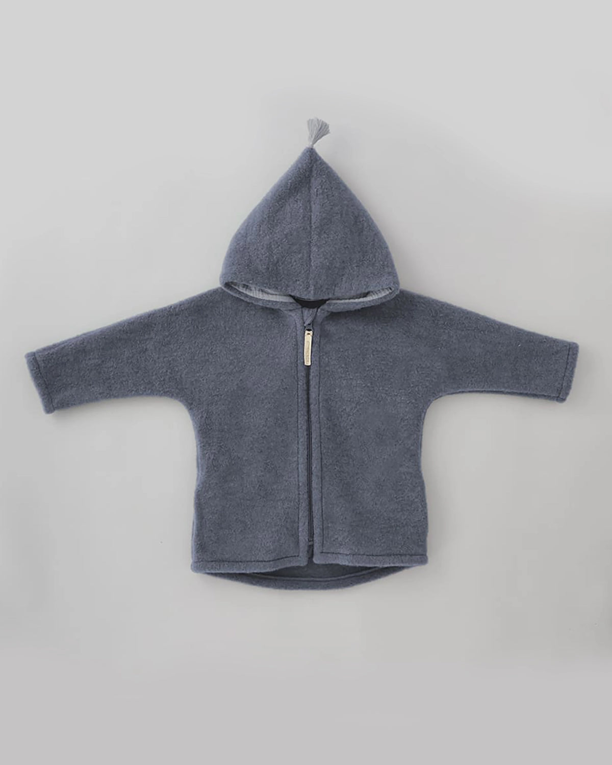 Kitz Heimat Wollfleece-Jacke Cloudy Blue/Blue in Vorderansicht mit spitzer Kapuze, heller Quaste, langen Ärmeln und durchgehendem Reißverschluss.