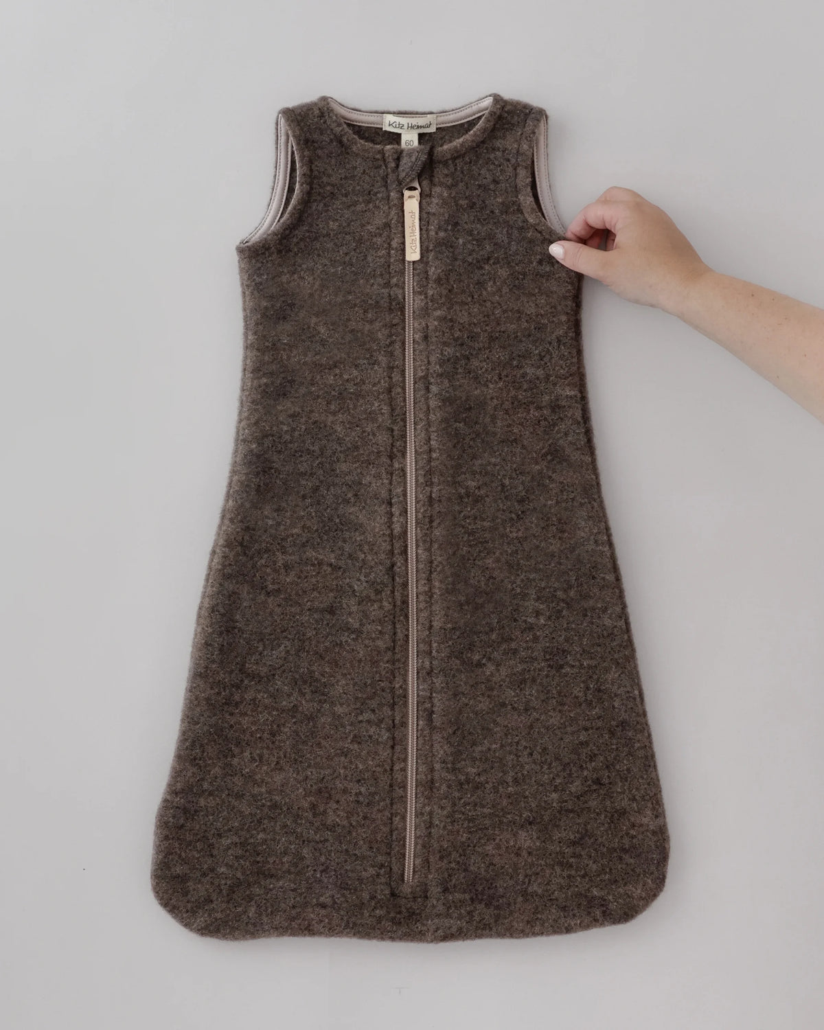 Kitz Heimat Wollfleece-Schlafsack Chocolate für Babys aus Bio-Merino-Schurwolle in Dunkelbraun mit ärmellosem Schnitt, langem Reißverschluss und abgerundetem Fußbereich.