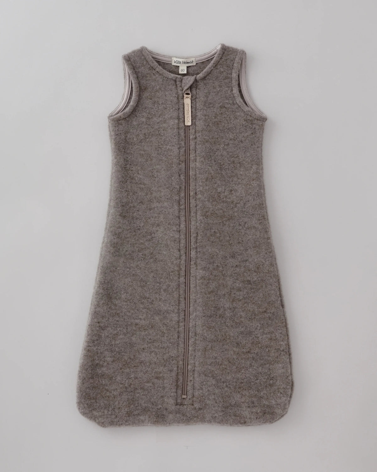 Kitz Heimat Wollfleece-Schlafsack Greige für Babys aus Bio-Merino-Schurwolle mit ärmellosem Schnitt, langem Reißverschluss und abgerundetem Fußbereich in Vorderansicht.